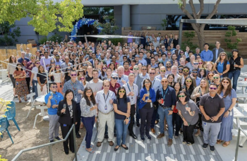 Arm team members posing for a large group photo in an outdoor setting